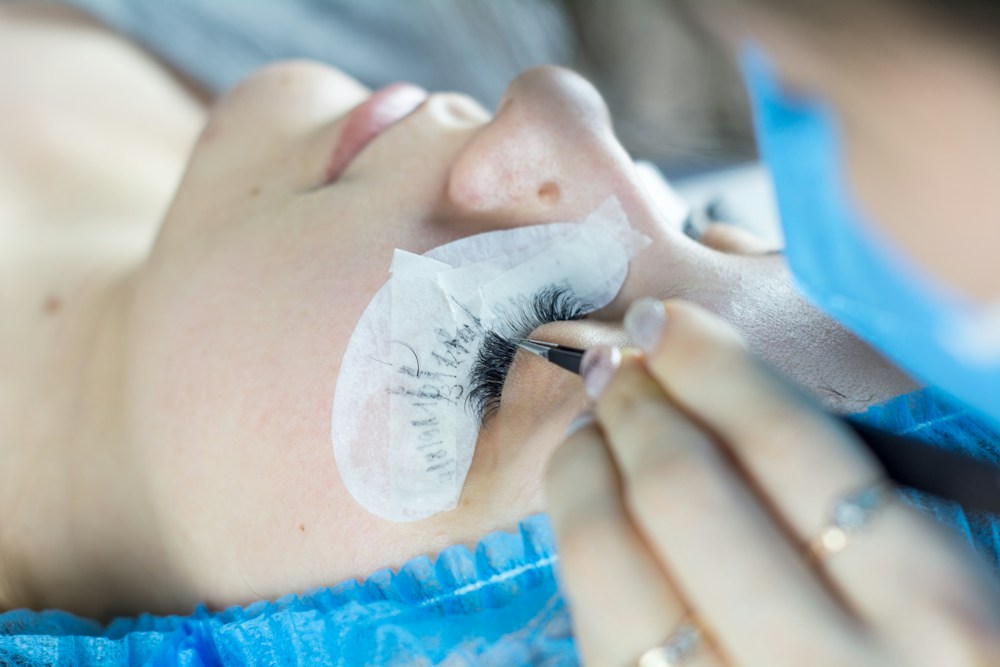 Präzise Wimpernverlängerung mit Pinzetten als Motiv für die praktische Schulung